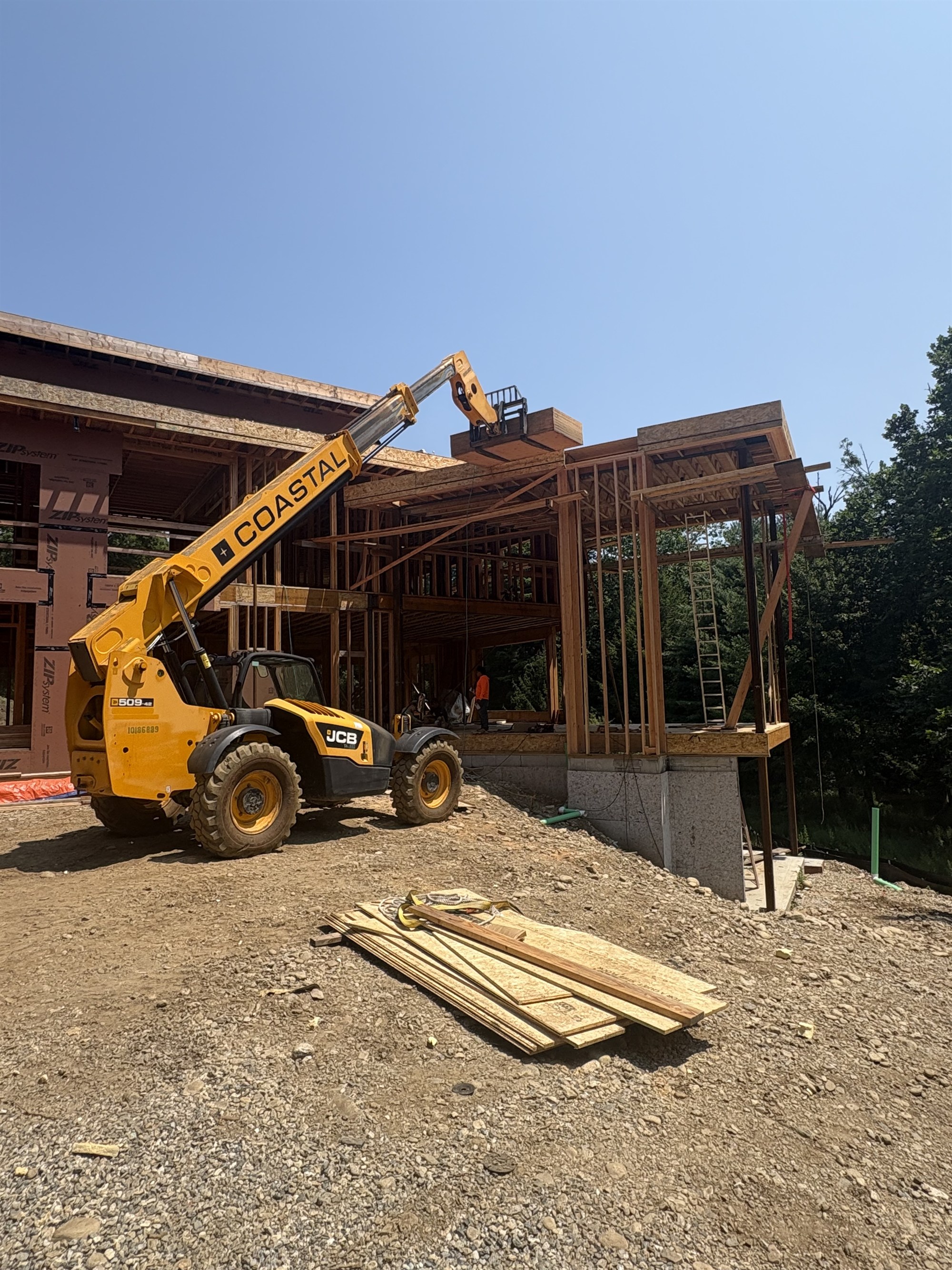 CLH telehandler handling materials at a custom home build